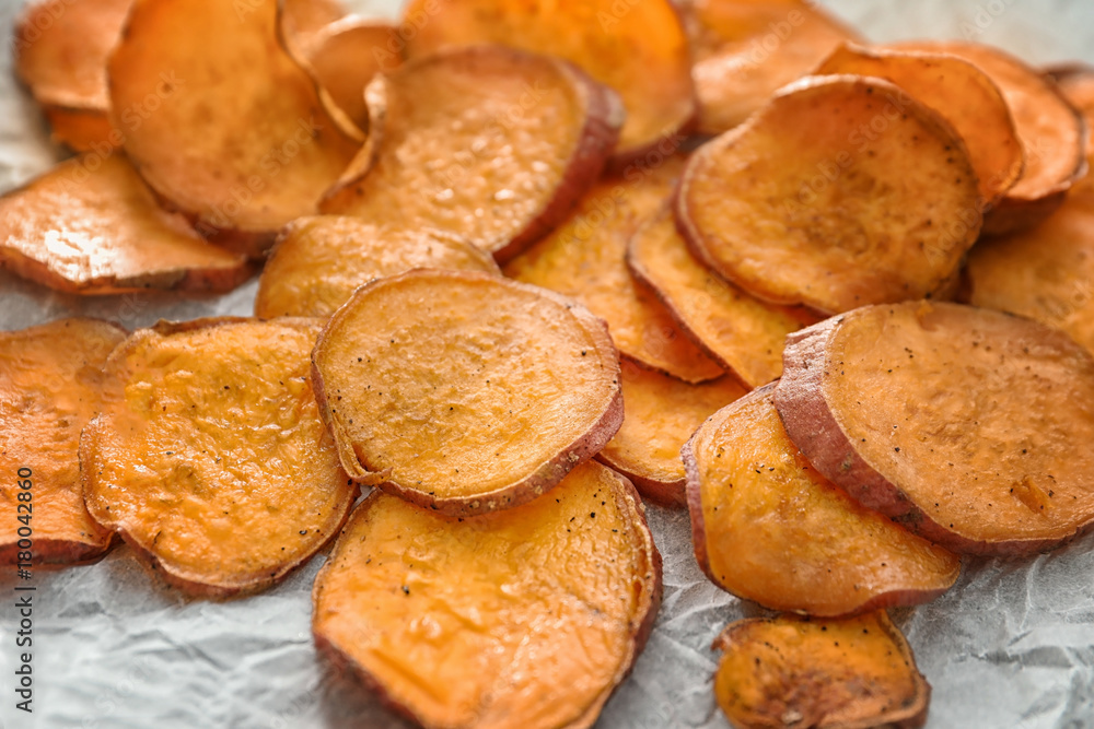 Yummy sweet potato chips on kitchen table, closeup