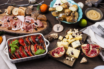 Served table with different food and snacks. red wine and two glasses