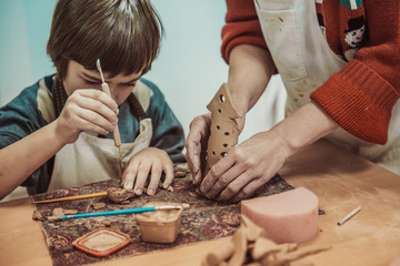 Wall Mural - The child is engaged in a pottery school, sculpts a clay product