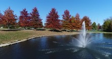 Fall Trees Around A Pond With A Fountain