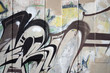 A fragment of detailed graffiti of a drawing made with aerosol paints on a wall of concrete tiles. Background image of street art in brown and cream tones