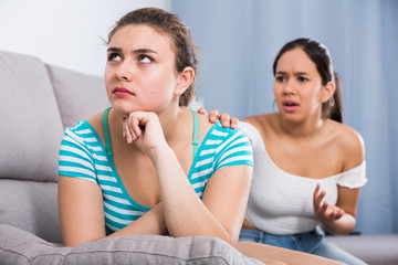 Two teenage girls squabbling at home