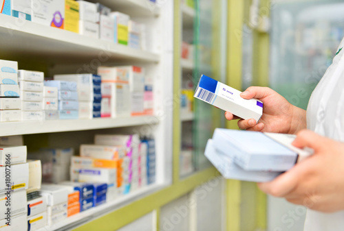 Fotomural Pharmacist holding medicine box in pharmacy drugstore.