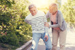 © zinkevych - In the back. Sad unhappy elderly man standing together with his wife and feeling pain in the back while having a walk