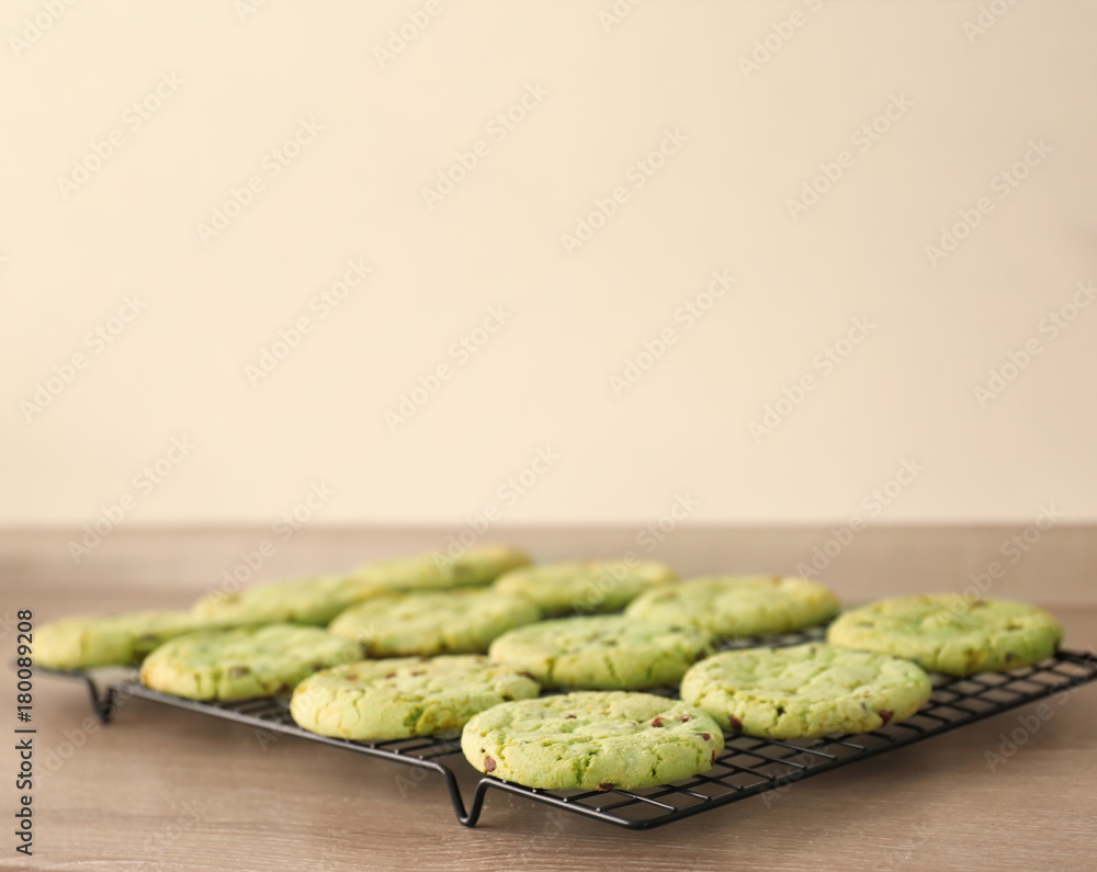 Baking grid with mint chocolate chip cookies on wooden table