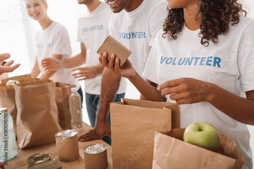 Fotografía volunteers packing food and drinks for charity