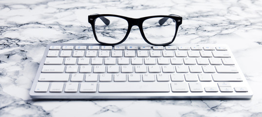 Eye glasses on a Desk or office scene with keyboard