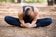 Woman practicing yoga in the sand - Bound Angle Pose Forward - Baddha Konasana - Autumn day