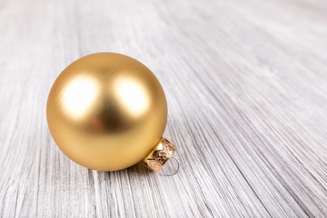 gold christmas ball on a white wooden background