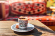 Authentic traditional Turkish coffee in a mug with national patterns on a wooden table in a local restaurant