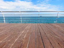 Wooden Pier With And Steel Railings Over The Sea Shore With Copy Space. Pier At The Sea. Sea View From The Viewing Platform Of Wooden Boards