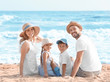 © Africa Studio - Happy family sitting on sea beach at resort