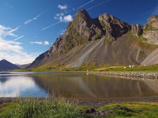 view on mountains green grass and sea lake on eastern fjords Iceland