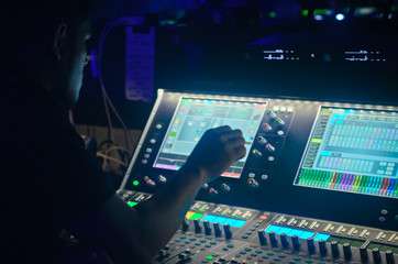 Sound engineer working at mixing panel in the boutique recording in pub