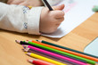Kind malt und bastelt mit Buntstiften und Schere in Kindergarten, Schule und Hort