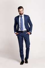 Perfect suit. Full length of handsome young man in suit looking at camera while standing against white background.