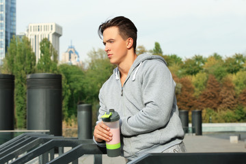 Poster - Sporty young man with protein shake, outdoors