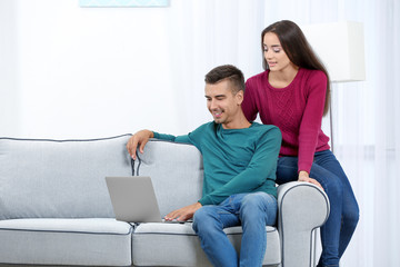 Canvas Print - Young couple with laptop on sofa at home