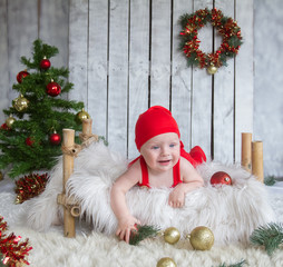 happy baby dressed in santa claus costume on christmas and new year decoration background, studio shot