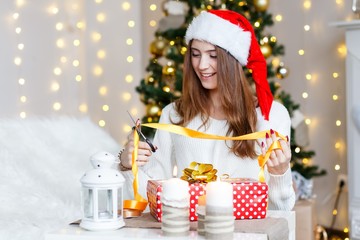 Wall Mural - A happy cheerful girl celebrating new year wrapping presents