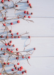 Wall Mural - Red winter hawthorn berries on a white wood background. New Year background