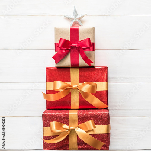 Gift Box Present Stack In Christmas Tree Shape With Red Gold Luxury Ribbon Star Top On White Pine Wood Backdrop For Xmas Boxing Day And Winter Holiday Seasonal Celebration Background Buy This