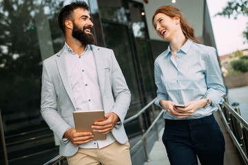 Young business couple walking outdoor near office building