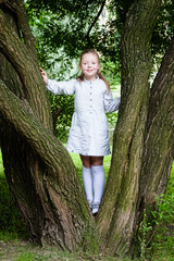 Girl climbs in Park on a tree in the summer