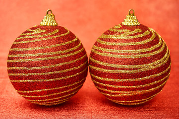 Two Red Christmas toy with gold stripes on a red background close-up. New Year, christmas background.