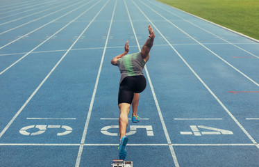 Wall Mural - sprinter taking off from starting block on running track