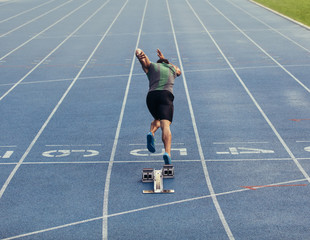 Wall Mural - sprinter taking off from starting block on track