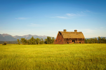 Wall Mural - Summer sunset with an old barn in rural Montana