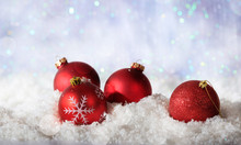 Red Christmas Balls On Christmas Snowy Bokeh Background