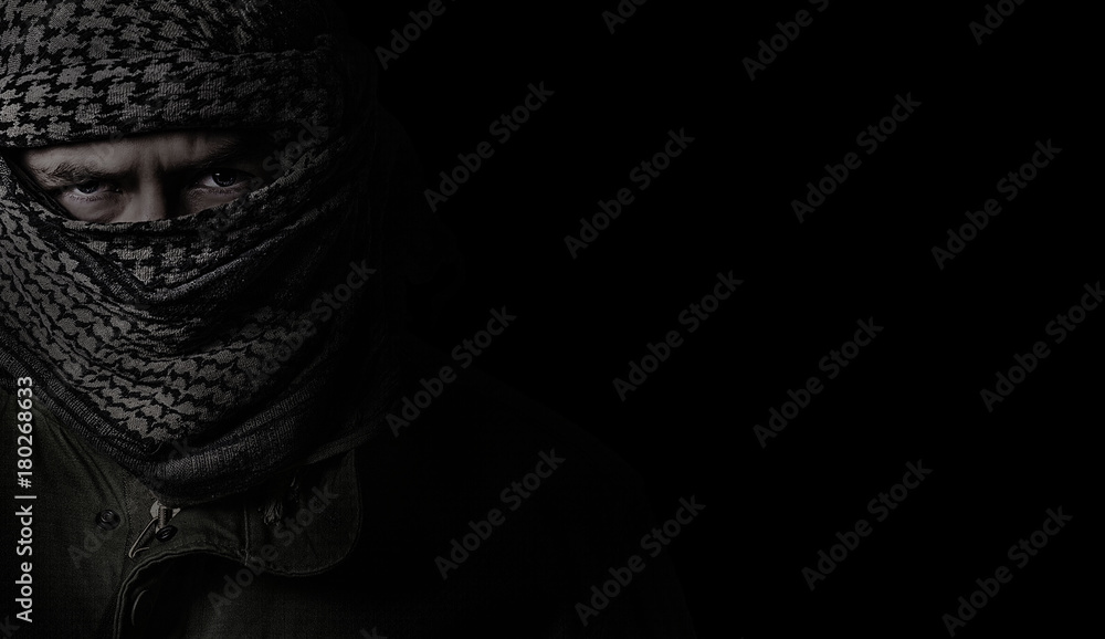 angry soldier in a camouflage scarf shemag on a black background - obrazy, fototapety, plakaty 