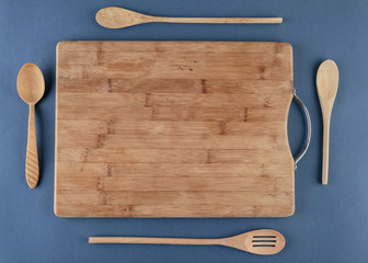 kitchen cutting board and a wooden spoon on a blue