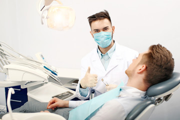 Wall Mural - A young male dentist and a patient