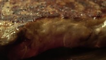 Grilled Ribeye Steak Being Turned On The Grill To Show Sizzling Grill Marks.. Close-up Macro Footage.