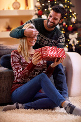 Wall Mural - man surprises woman with Christmas gift.