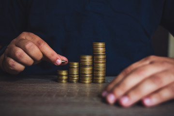 Man stacking money as concept for success or savings, investment and accounting