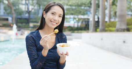 Canvas Print - Woman eating fish ball in Hong Kong, famous street food