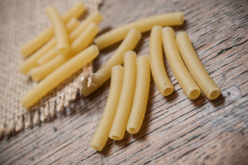 pâtes macaroni  et toile de jutte sur table en bois