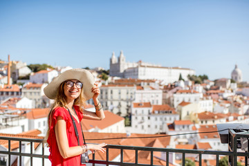 Wall Mural - Young woman tourist enjoying beautiful cityscape view on the Alfama region of Lisbon city during the morning light in Portugal