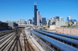 Downtown Chicago skyline over railroads with passenger trains