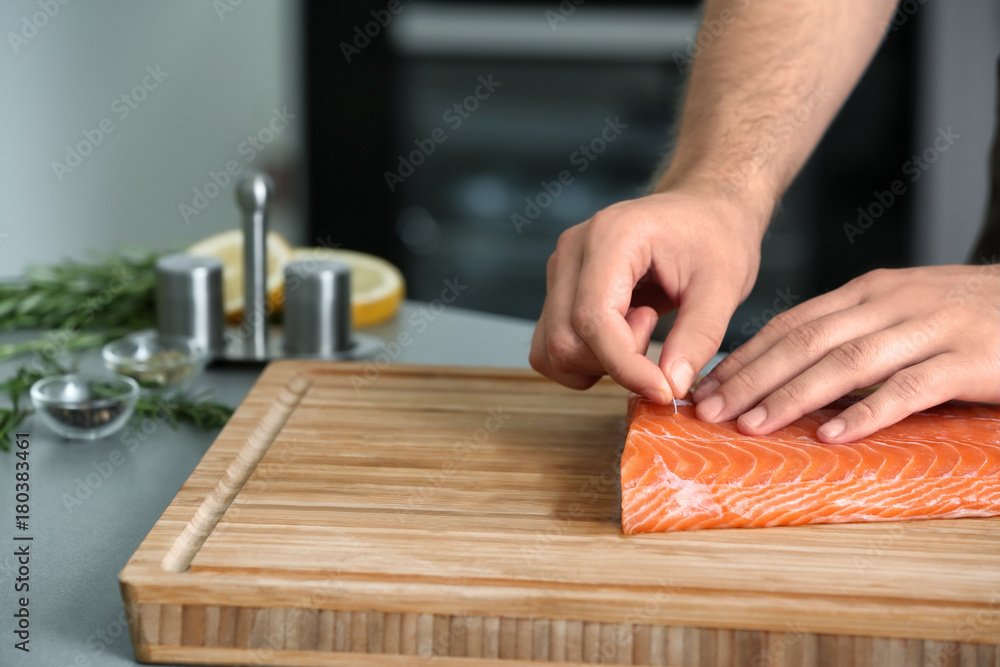 Man cooking salmon fillet in kitchen