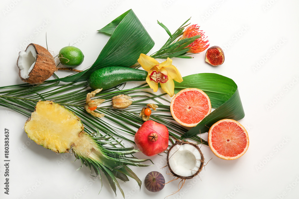 Composition with tropical leaves and exotic fruits on light background