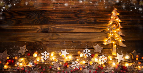 Wall Mural - Christmas background with wooden decorations, tree and spot lights.