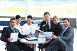 © ASDF - group of business people with documents sitting at a table in the lobby of the Bank.