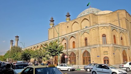 Canvas Print - The traffic in Mostafa Khomeini street with the medieval building of Shahid Motahari (Sepahsalar) mosque and madrasa on the background in Tehran.