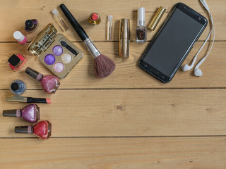 Top view of a set of women's cosmetics on a wooden table. Place for text.