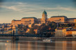 Budapest, Hungary - Beautiful golden sunrise at the Buda side with Buda Castle Royal Palace, Szechenyi Chain Bridge and sightseeing boat on River Danube